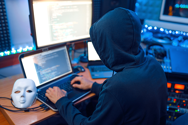 Hacker usando laptop e fazendo ataques de negação em redes