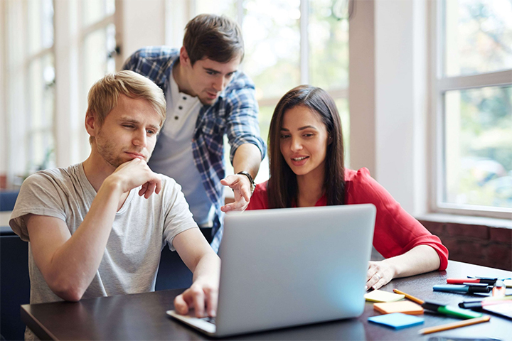 Dois homens e uma mulher arquiteto de soluções de ti analisando dados no laptop