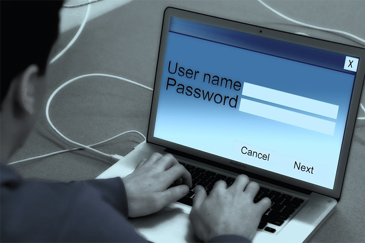 Homem digitando seu login e senha em laptop para fazer teste de invasão