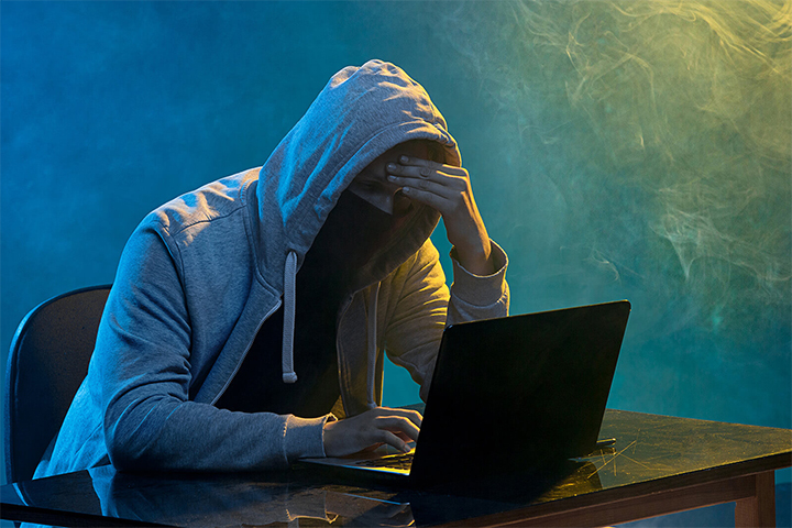 Hacker usando laptop para acessar sistemas para proteger do attacker
