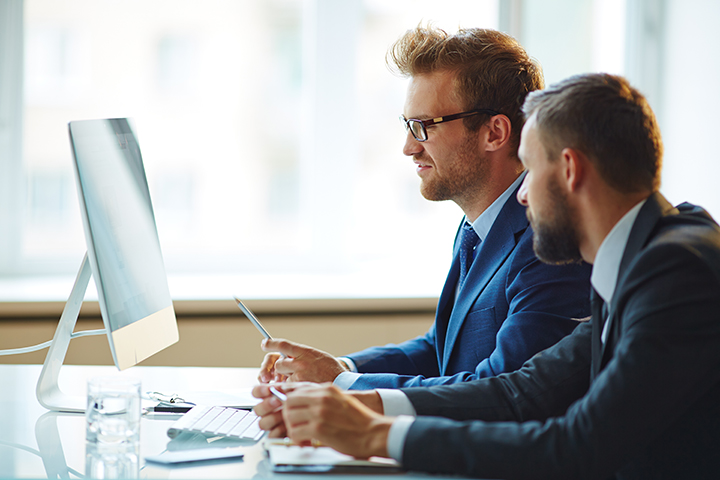 Homens trabalhando no computador usando ITIL 4