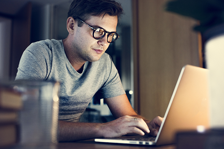 Homem trabalhando no computador fazendo boas práticas da programação SQL
