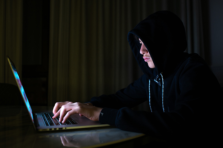 Hacker usando laptop e acessando a internet para ataques