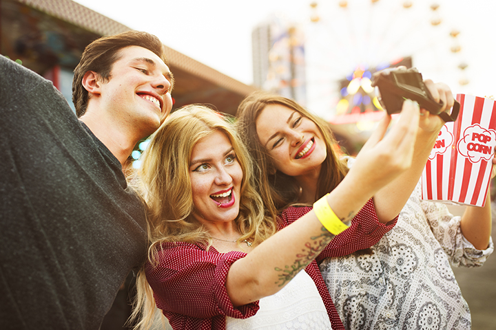 Pessoas felizes no parque de diversão fazendo selfie devido a inserção da ITIL