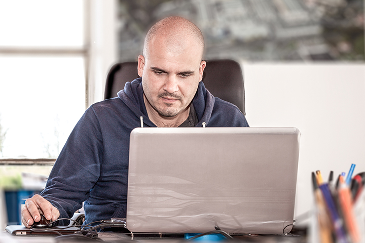 Homem usa laptop para fazer exame online do CobiT 5