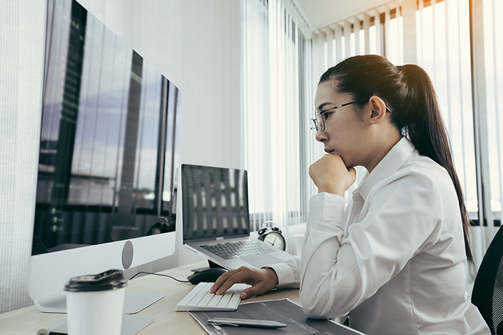 Mulher trabalhando em desktop com sistema de qualidade