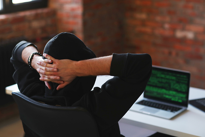 Hacker usando o seu laptop e aplicando ataques de botnets