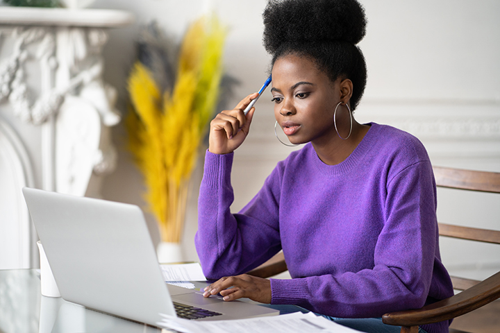 Mulher usando laptop para fazer o seu exame online e tirar certificado